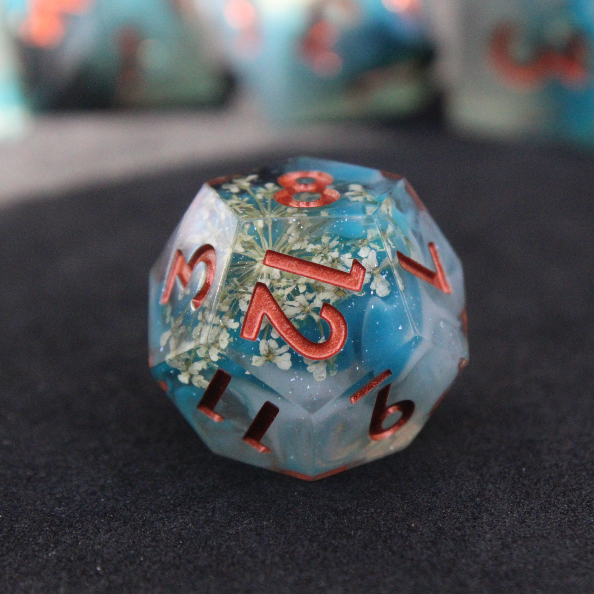 Blue sharp edge dice with white flowers inside. Used in tabletop roleplaying games like Dungeons & Dragons, DND, D&D, Pathfinder.