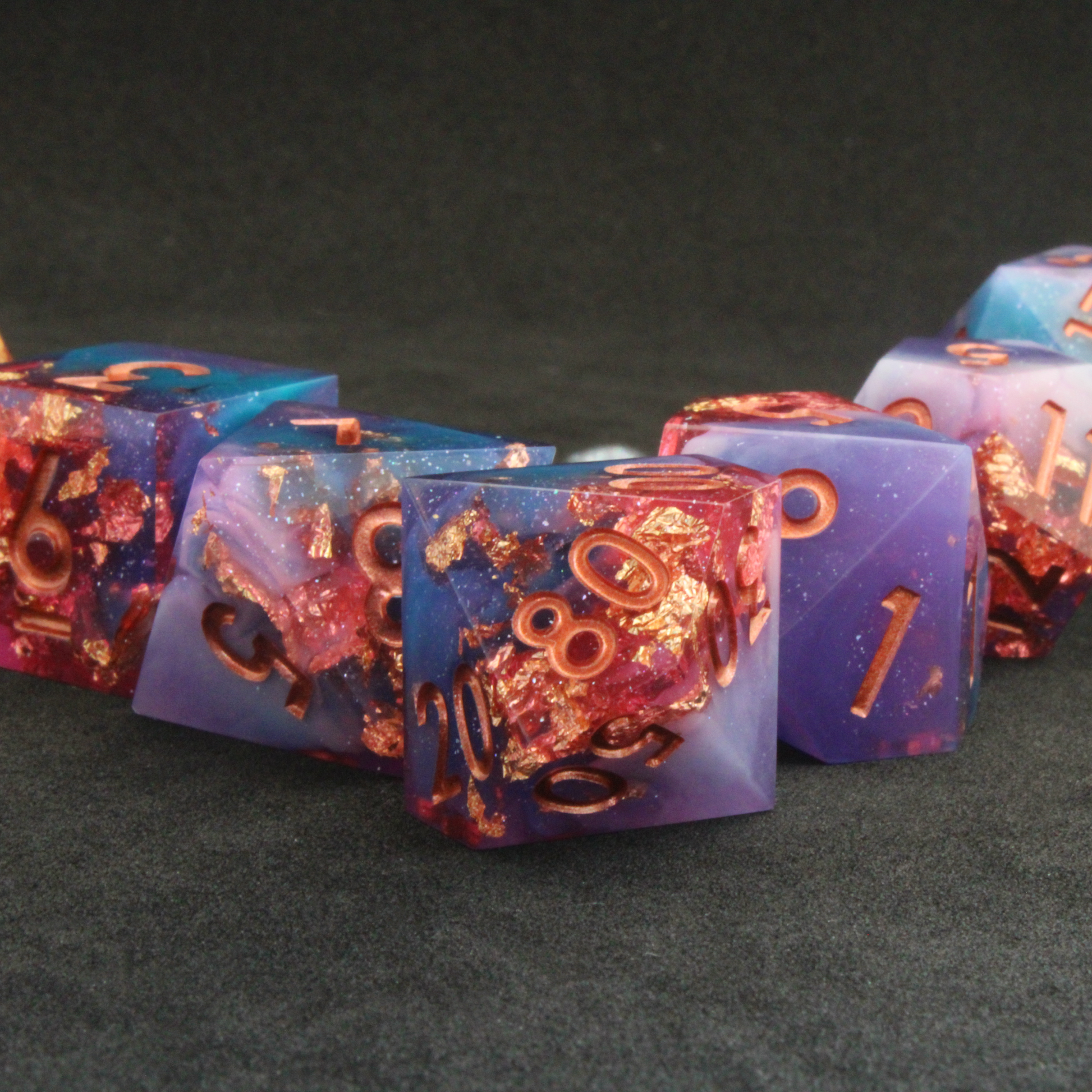 Set of blue, pink and purple sharp edge dnd dice. These polyhedral dice are used for tabletop roleplaying games like Dungeons & Dragons / D&D and Pathfinder.