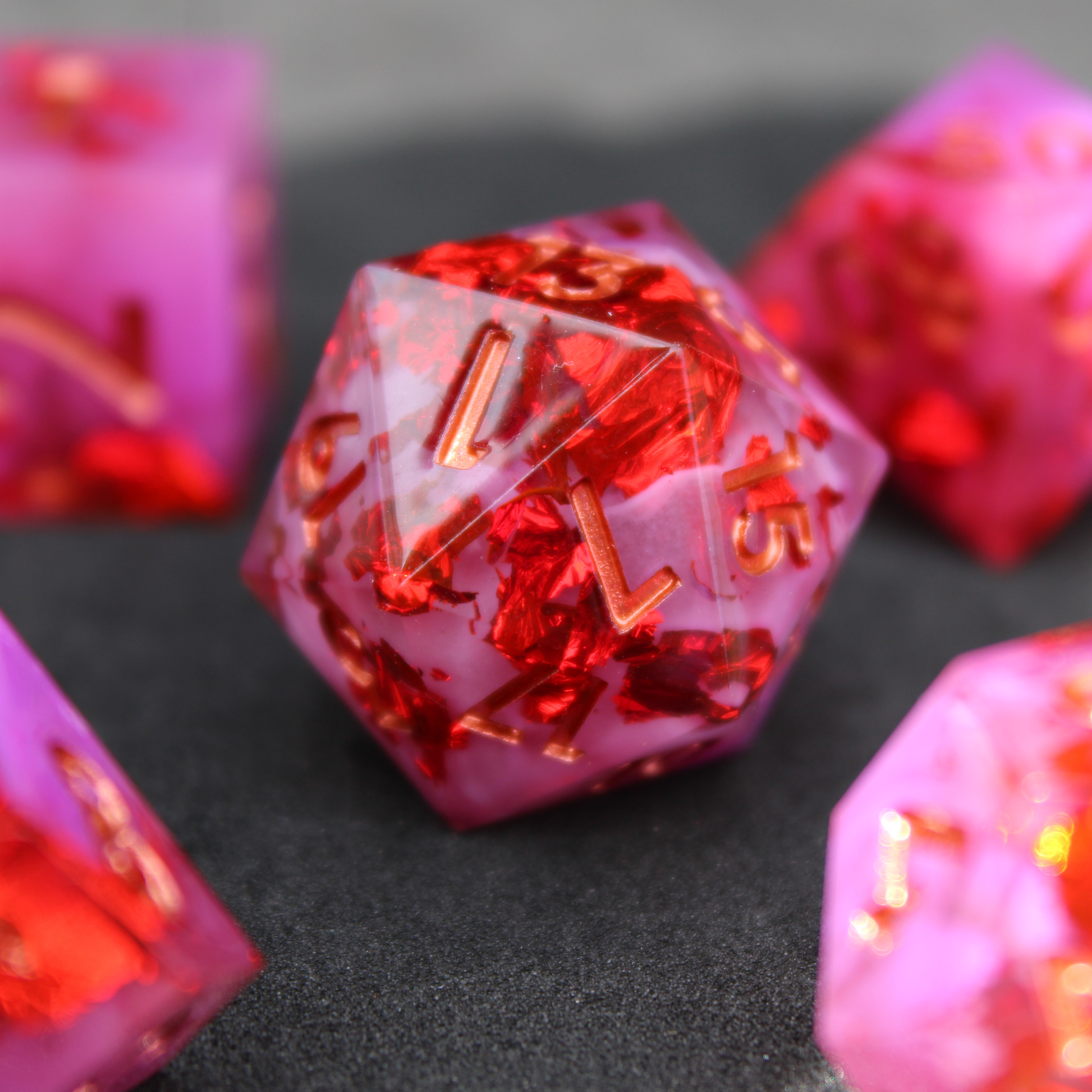 Purple pink and red sharp edge dnd dice. These polyhedral dice are used to play TTRPGs like Dungeons & Dragons / D&D and Pathfinder.
