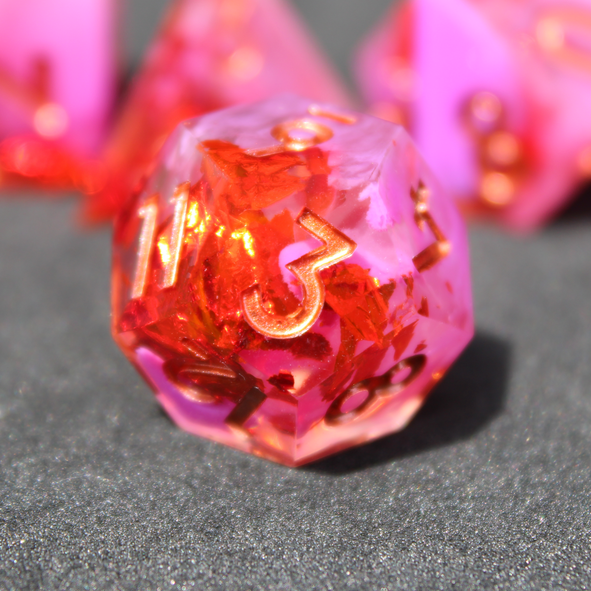 Purple pink and red sharp edge dnd dice. These polyhedral dice are used to play TTRPGs like Dungeons & Dragons / D&D and Pathfinder.