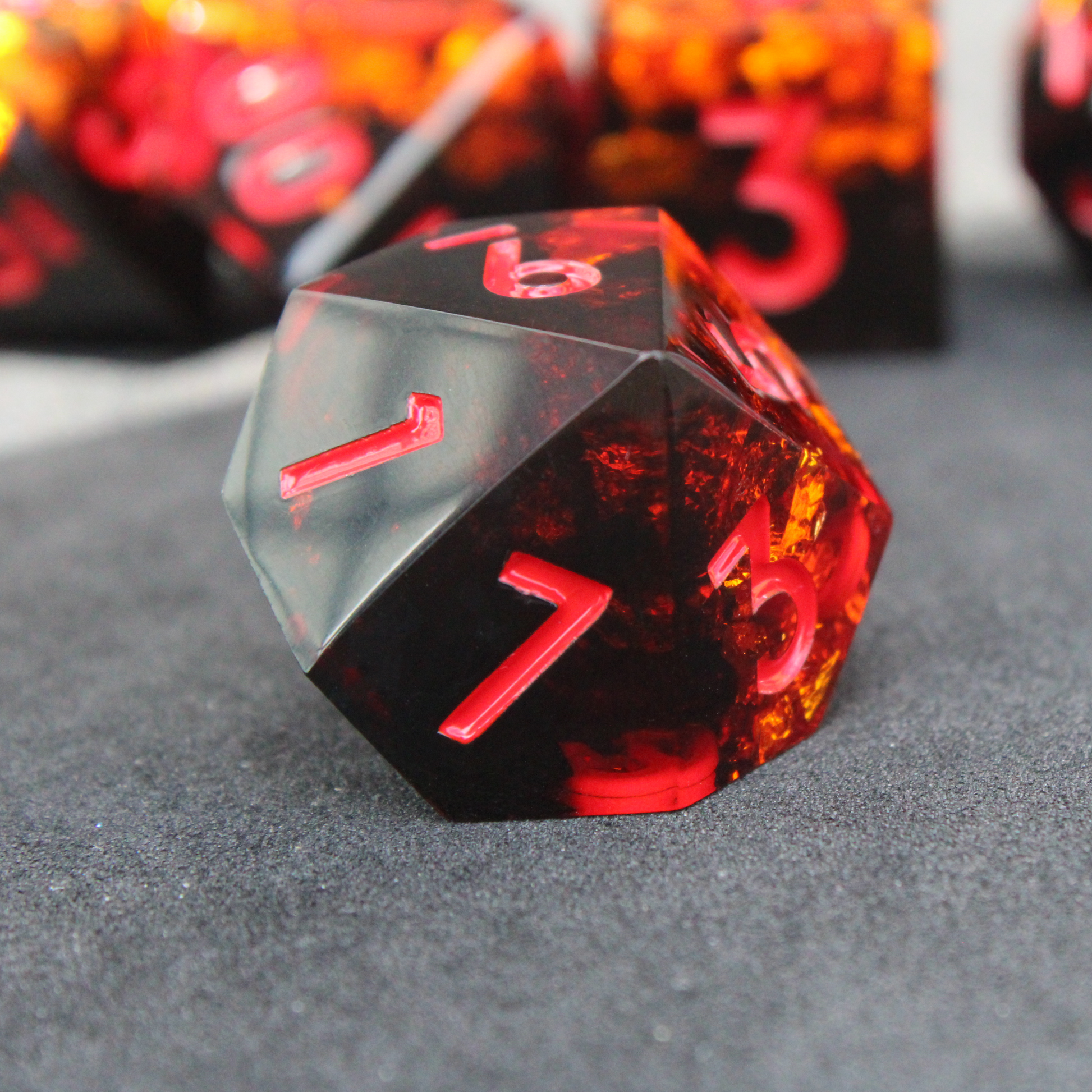 Black and orange sharp edge dnd dice set made of resin and made to look like fire. These polyhedral dice are used to play TTRPGs like Dungeons & Dragons / D&D and Pathfinder.