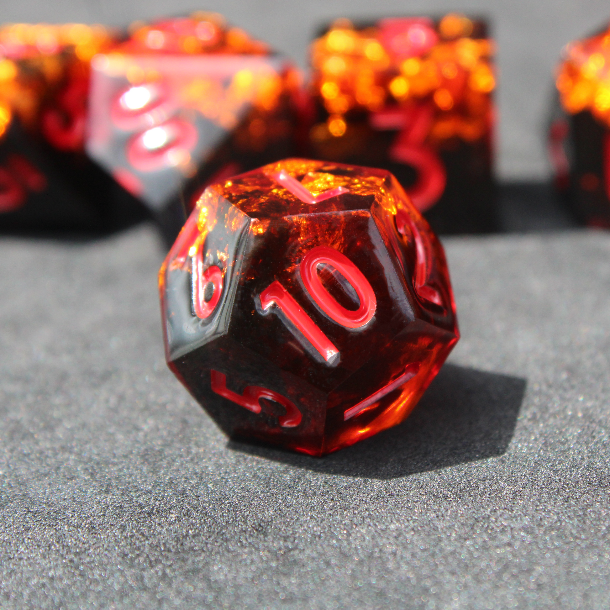 Black and orange sharp edge dnd dice set made of resin and made to look like fire. These polyhedral dice are used to play TTRPGs like Dungeons & Dragons / D&D and Pathfinder.
