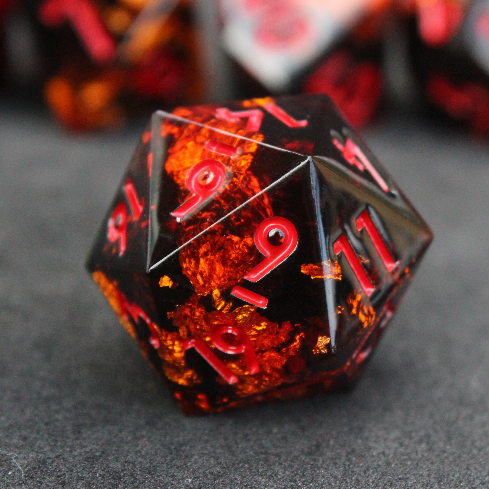 Black and orange sharp edge dnd dice set made of resin and made to look like fire. These polyhedral dice are used to play TTRPGs like Dungeons & Dragons / D&D and Pathfinder.