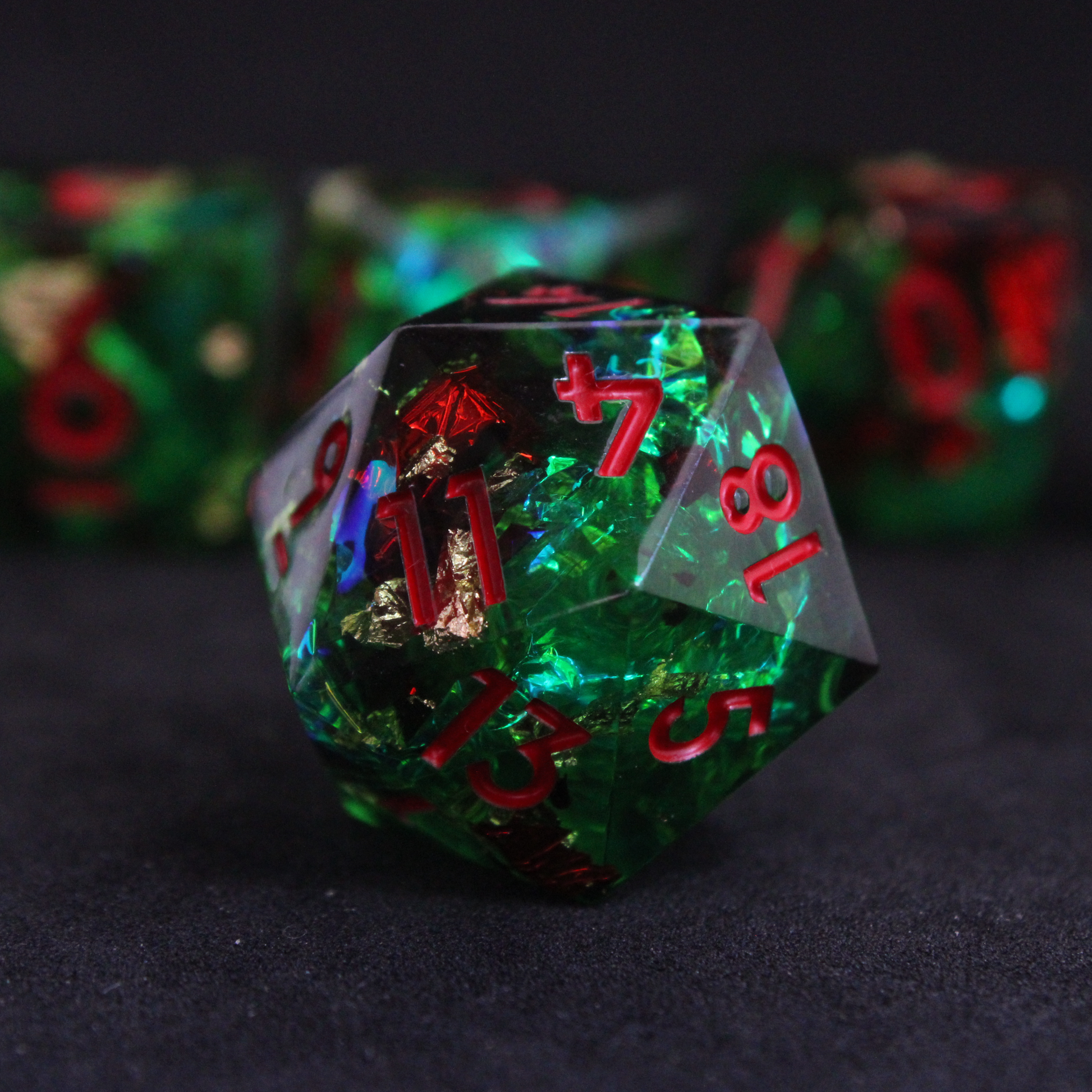 Green resin DND sharp edge dice with red and blue holographic foils. These polyhedral dice are used in TTRPGs like Dungeons & Dragons / D&D and Pathfinder.