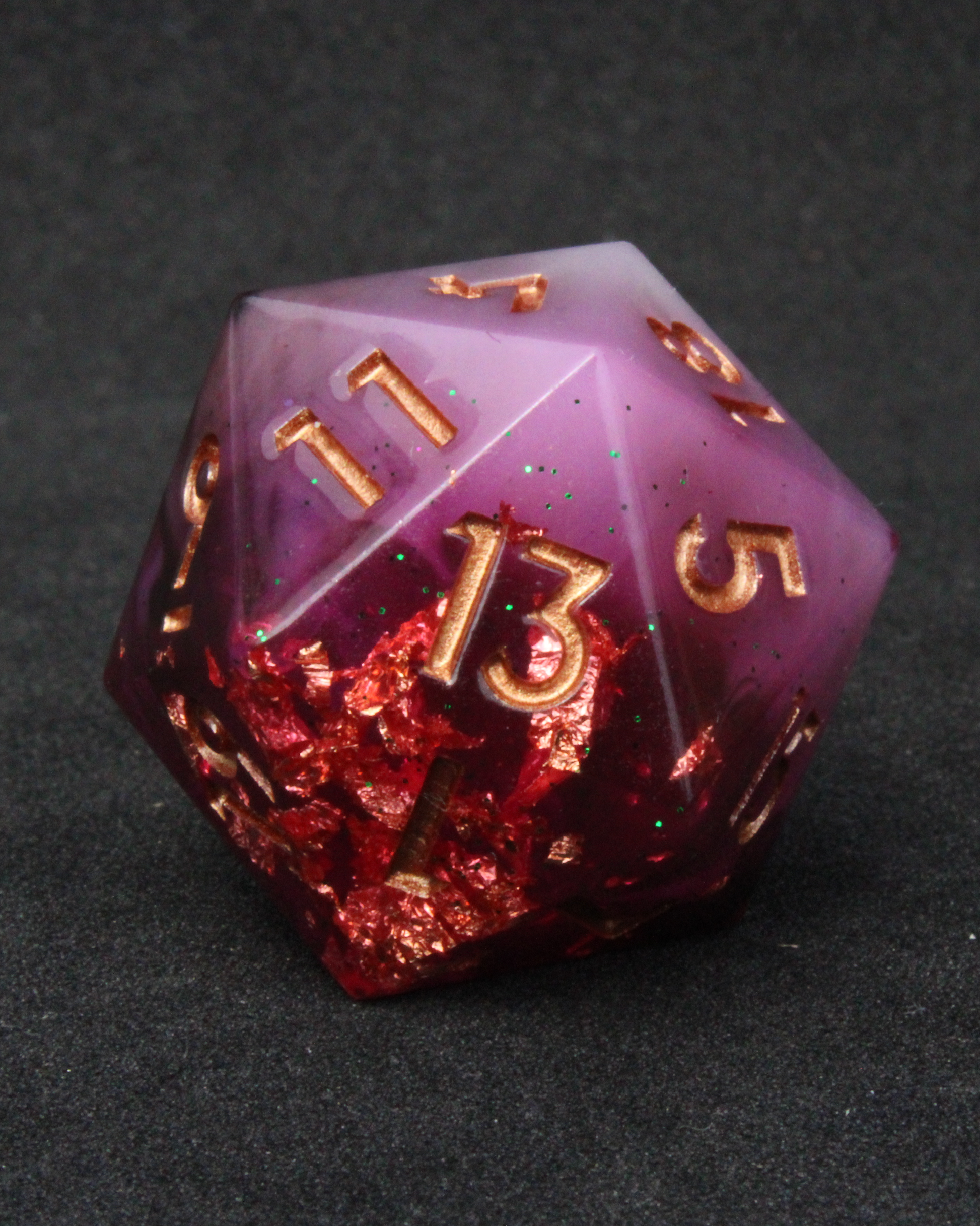 Black, pink and red resin sharp edge dice. These polyhedral dice are used to play TTRPGs like Dungeons & Dragons / D&D / DND and Pathfinder.