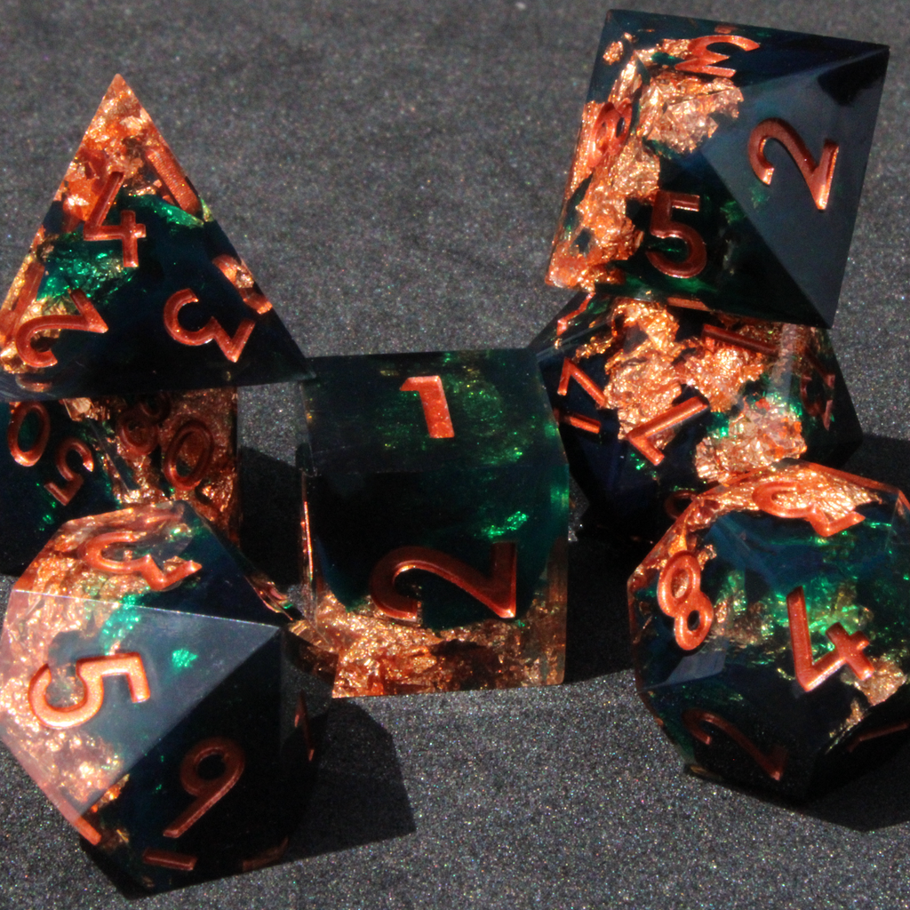 Dark green and black resin sharp edge dice with copper flakes and glitter inside it. The polyhedral dice are used for tabletop roleplaying games like Dungeons & Dragons / DND / D&D and Pathfinder.
