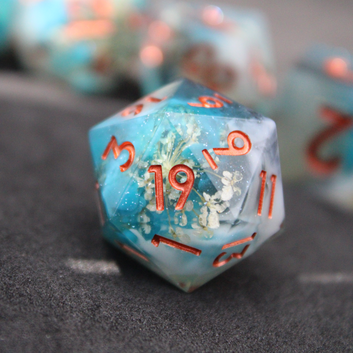 Blue sharp edge dice with white flowers inside. Used in tabletop roleplaying games like Dungeons & Dragons, DND, D&D, Pathfinder.