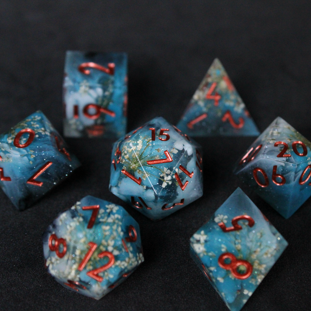 Blue sharp edge dice set featuring white flowers set inside. Used in TTRPGs like Dungeons & Dragons, Pathfinder, D&D, DnD