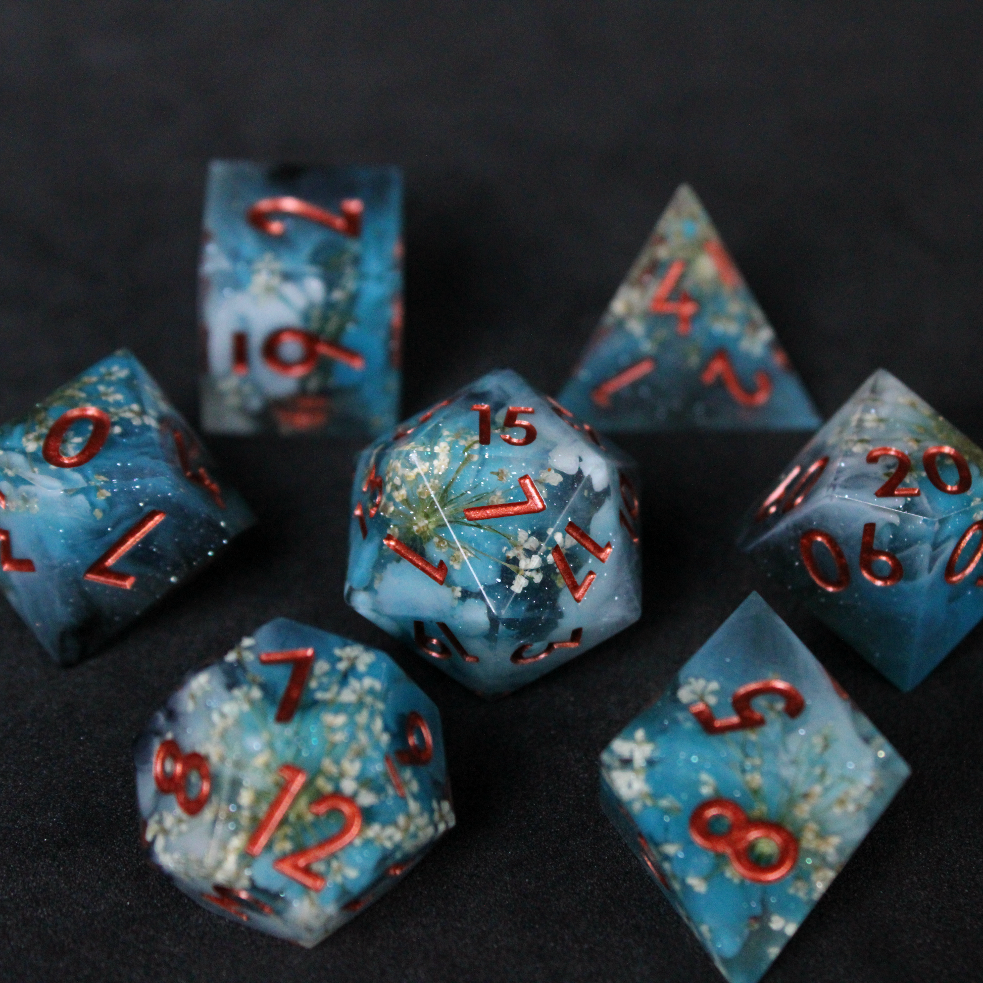 Blue sharp edge dice set featuring white flowers set inside. Used in TTRPGs like Dungeons & Dragons, Pathfinder, D&D, DnD