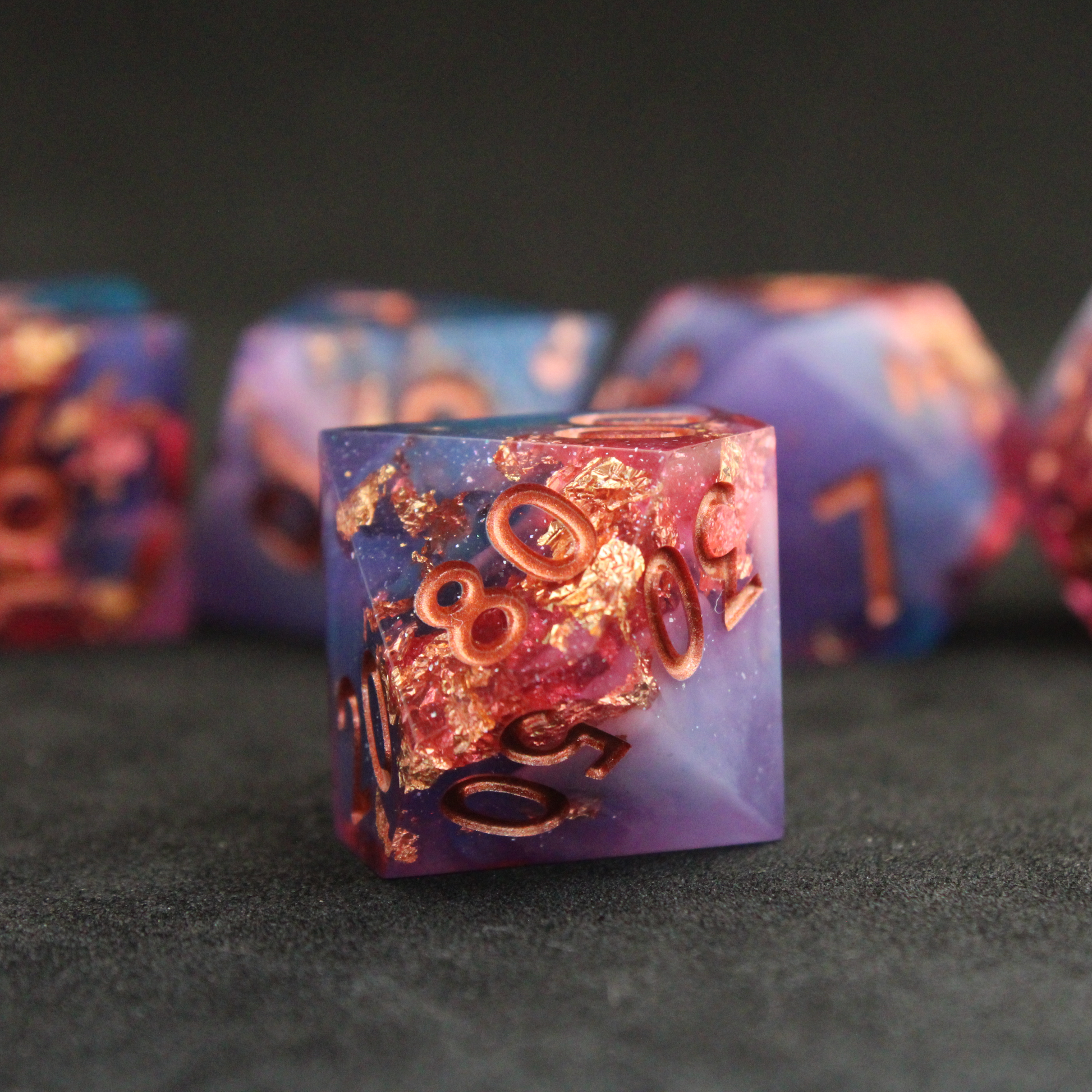 Set of blue, pink and purple sharp edge dnd dice. These polyhedral dice are used for tabletop roleplaying games like Dungeons & Dragons / D&D and Pathfinder.
