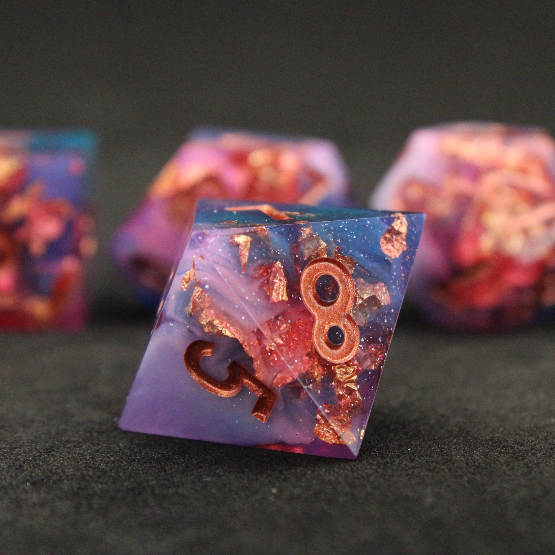 Set of blue, pink and purple sharp edge dnd dice. These polyhedral dice are used for tabletop roleplaying games like Dungeons & Dragons / D&D and Pathfinder.