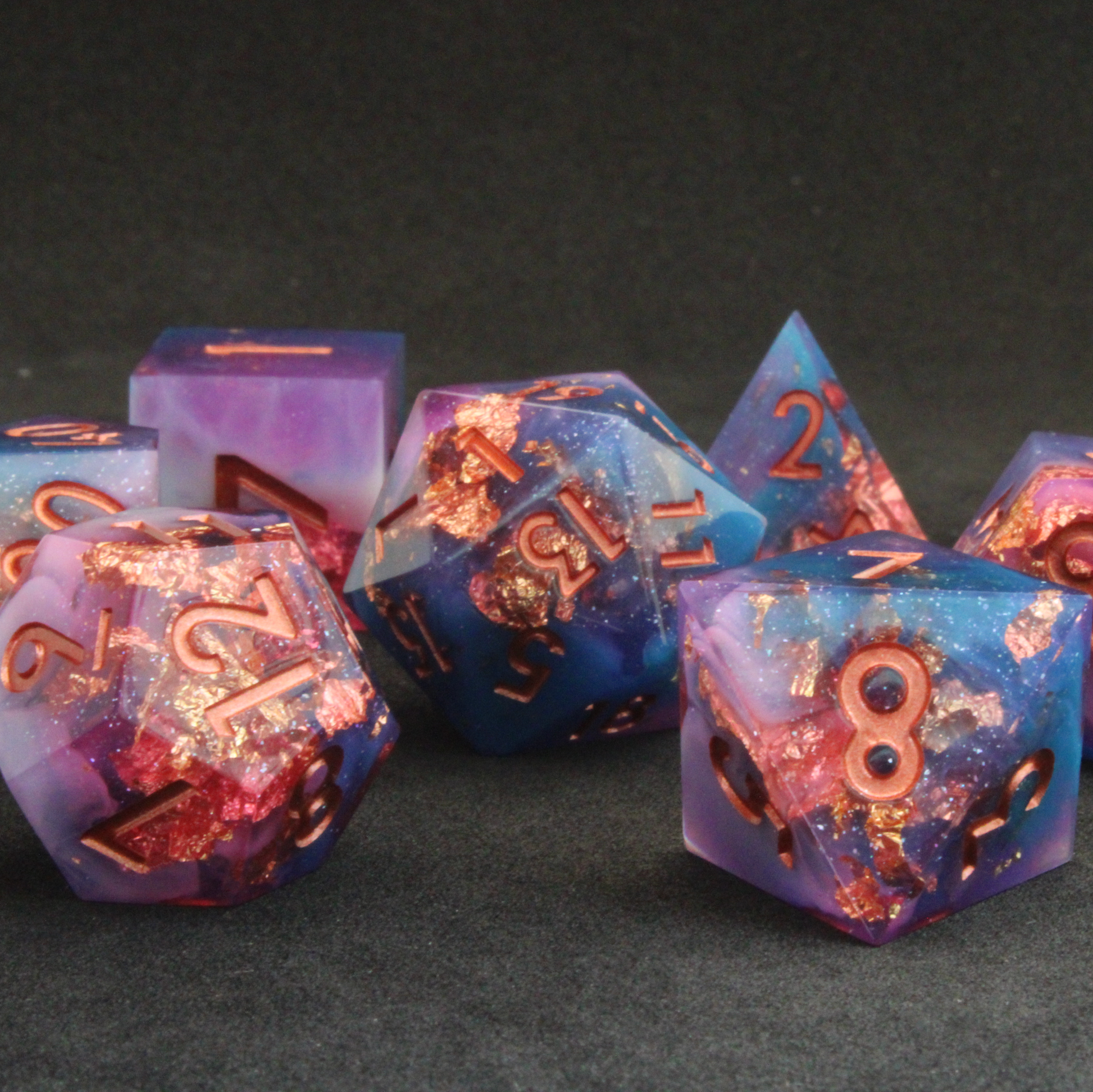 Set of blue, pink and purple sharp edge dnd dice. These polyhedral dice are used for tabletop roleplaying games like Dungeons & Dragons / D&D and Pathfinder.