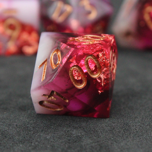 Black, pink and red resin sharp edge dice. These polyhedral dice are used to play TTRPGs like Dungeons & Dragons / D&D / DND and Pathfinder.