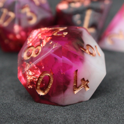 Black, pink and red resin sharp edge dice. These polyhedral dice are used to play TTRPGs like Dungeons & Dragons / D&D / DND and Pathfinder.
