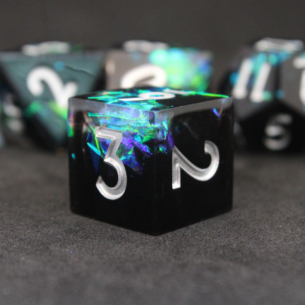 Black and blue sharp edge dnd dice set made of resin and made to look like lightning in a bottle. These polyhedral dice are used to play TTRPGs like Dungeons & Dragons / D&D and Pathfinder.