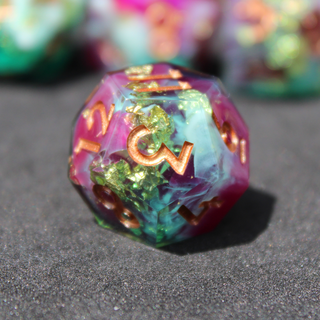 Purple blue and green sharp edge dice made of resin. These polyhedral dice are used for playing TTRPGs like Dungeons & Dragons (D&D / DND) and Pathfinder.