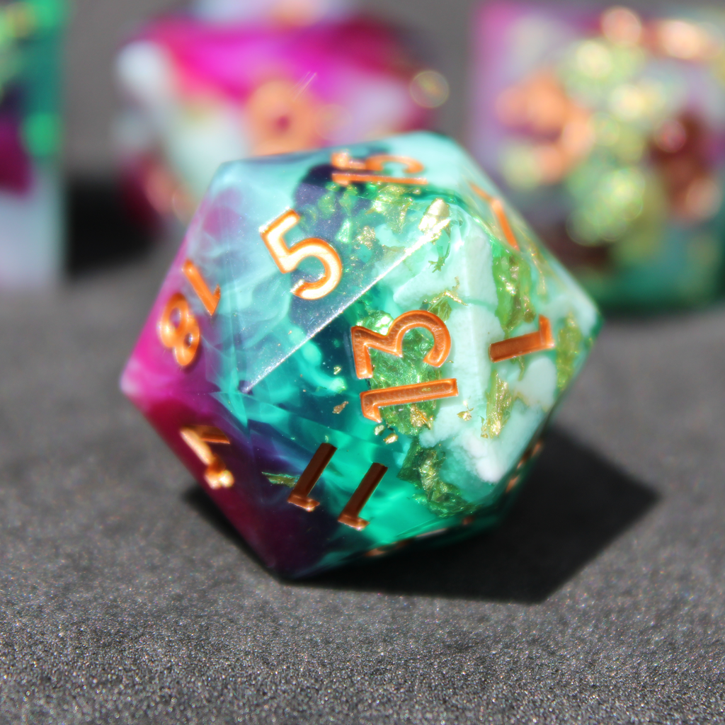 Purple blue and green sharp edge dice made of resin. These polyhedral dice are used for playing TTRPGs like Dungeons & Dragons (D&D / DND) and Pathfinder.