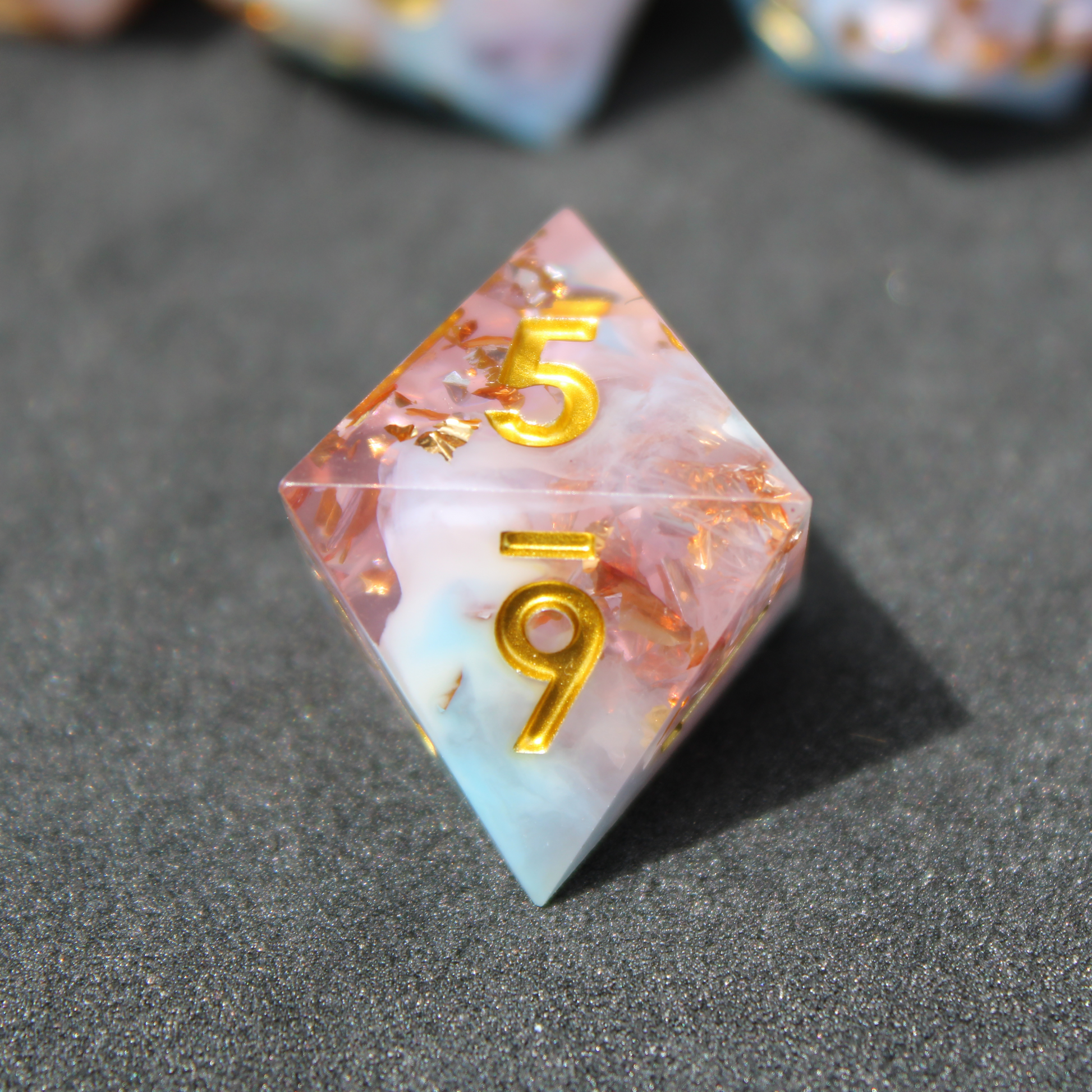 Blue and pink sharp edge dnd dice resembling candy floss. These polyhedral dice are used for playing TTRPGs like Dungeons & Dragons / D&D and Pathfinder.