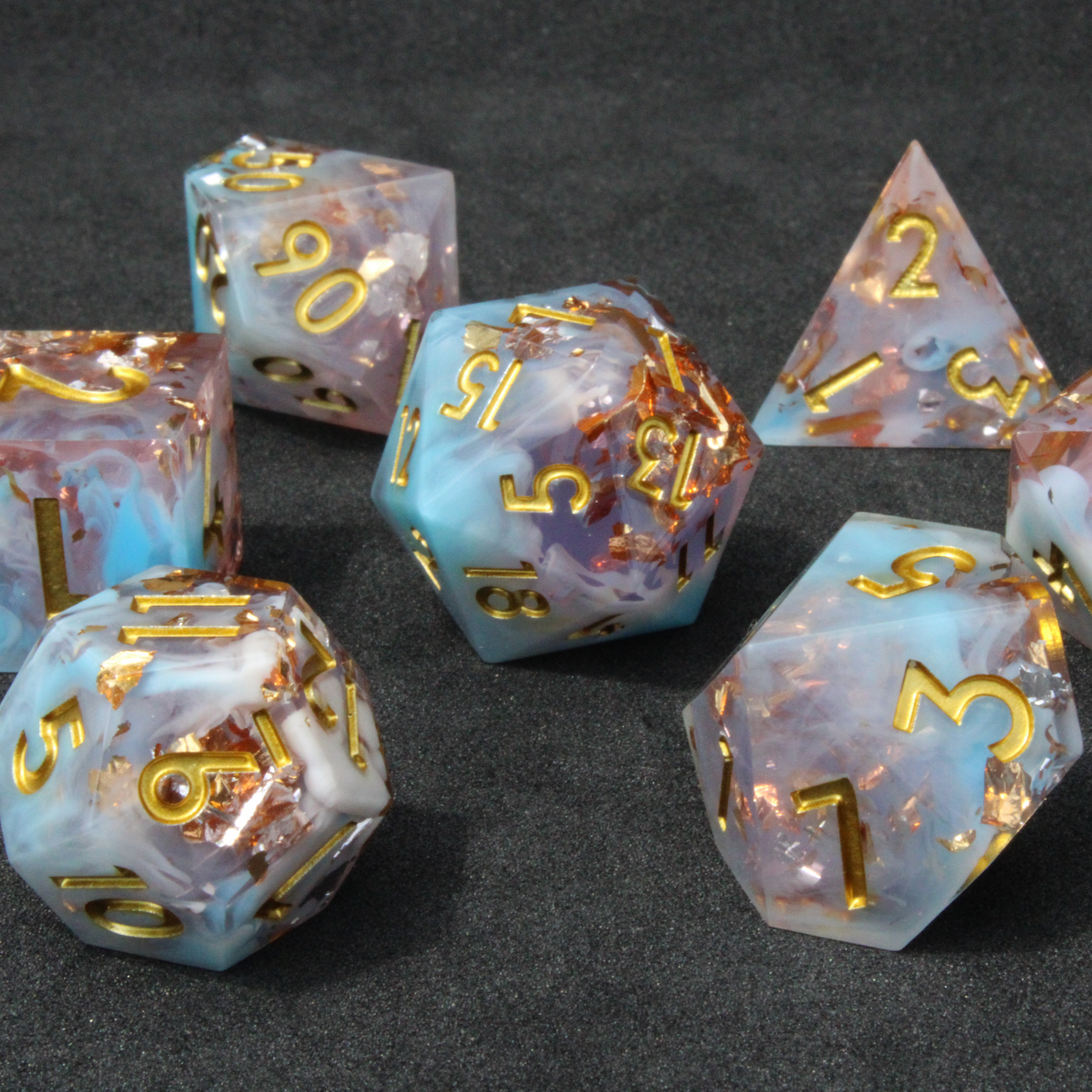 Blue and pink sharp edge dnd dice resembling candy floss. These polyhedral dice are used for playing TTRPGs like Dungeons & Dragons / D&D and Pathfinder.